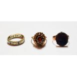 A 9 carat gold garnet cluster ring, finger size P; and two further 9 carat gold rings . Three 9