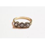 A diamond three stone ring, finger size T. Unmarked. Gross weight 2.81 grams.