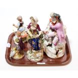 A 19th century porcelain figural group of a courting couple; together with four other porcelain
