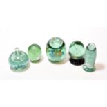 Five Victorian green glass dumps and inkwell dump paperweight, the largest with flower sulphides,