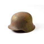 A German Third Reich M42 Steel Helmet, with sprayed pale green camouflage finish over the original