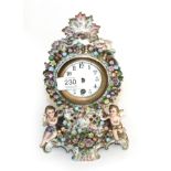 A floral encrusted porcelain mantel timepiece, early 20th century