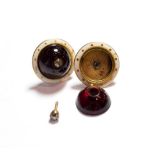 A pair of garnet and diamond earrings, a round cabocon garnet inset with an old cut diamond, to a