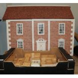 A dolls house complete with various bedroom and kitchen furniture