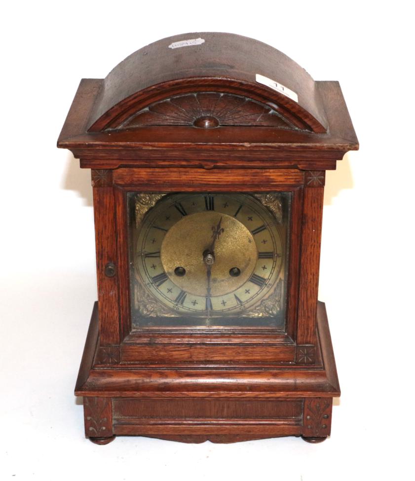 An oak cased striking mantel clock with brass dial, circa 1900