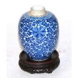 A Chinese blue and white floral decorated vase with a pierced hardwood stand