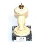 A carved ivory ornament in the form of a sundial raised on a marble base