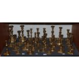 A large collection of brass candlesticks