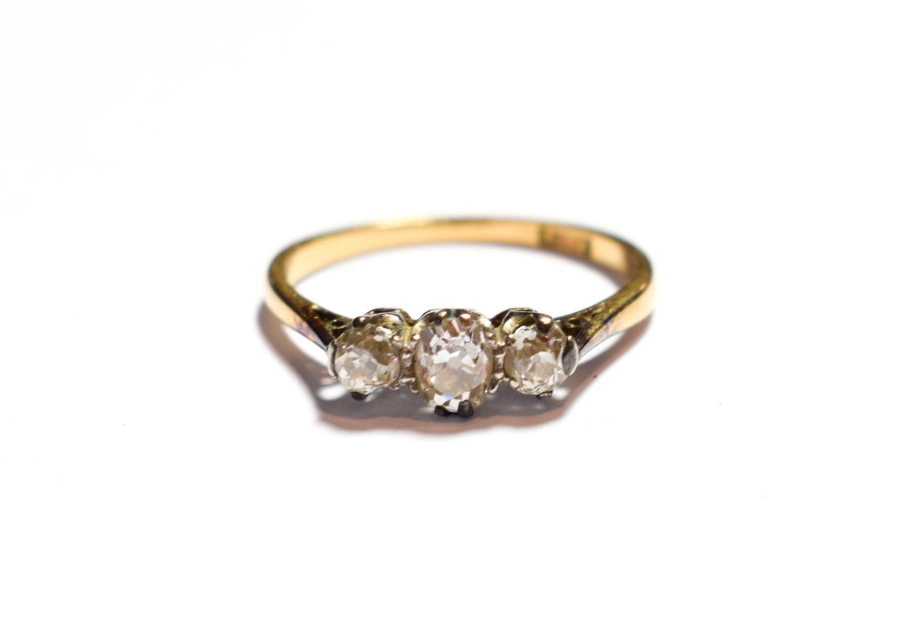 A diamond three stone ring, stamped '18CT', finger size N1/2. Gross weight 2.1 grams