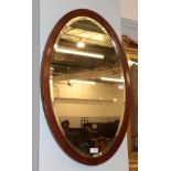 A reproduction cream painted mirror in the Victorian style; and an oval bevelled glass mirror (2)