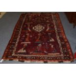 A Kashgai rug, the aubergine field with columns of dancing ladies around a stepped medallion,