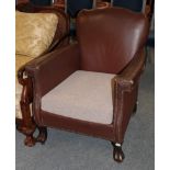 An early 20th century tub chair covered in brown close nailed leather