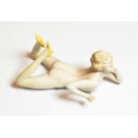 An early 20th century German bisque figure of a nude young woman, unmarked, modelled lying on