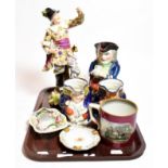 A German porcelain figure of a drunken soldier together with three Toby jugs and other ceramics (