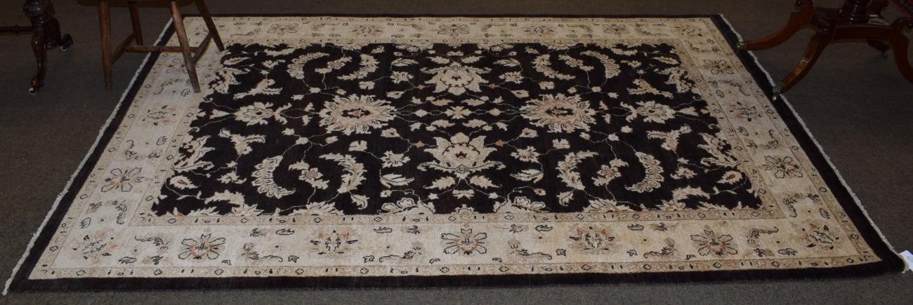 Afghan ''Ziegler'' carpet, the deep walnut brown field of scrolling vines enclosed by ivory borders,