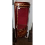 A reproduction French gilt metal mounted glazed bow fronted corner display cabinet, with painted