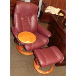 An Ekornes Stressless leather swivel chair, with adjustable tray and matching footstool