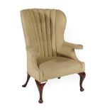 A George III Style Wing-Back Armchair, 19th century, covered in green fabric with curved back