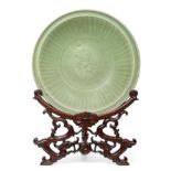 A Longquan Celadon Dish, Ming dynasty, carved with a central foliate panel within a broad fluted