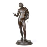 After the Antique: A Bronze Figure of Narcissus, standing on a circular plinth, 63cm high See
