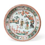 A Chinese Porcelain Charger, Kangxi, painted in famille verte enamels with figures in a fenced