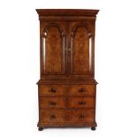 A Figured Walnut and Featherbanded Bookcase Cabinet, the cavetto cornice above a cushion shaped