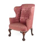 A George II Wing-Back Armchair, mid 18th century, recovered in pink floral damask, with outswept arm