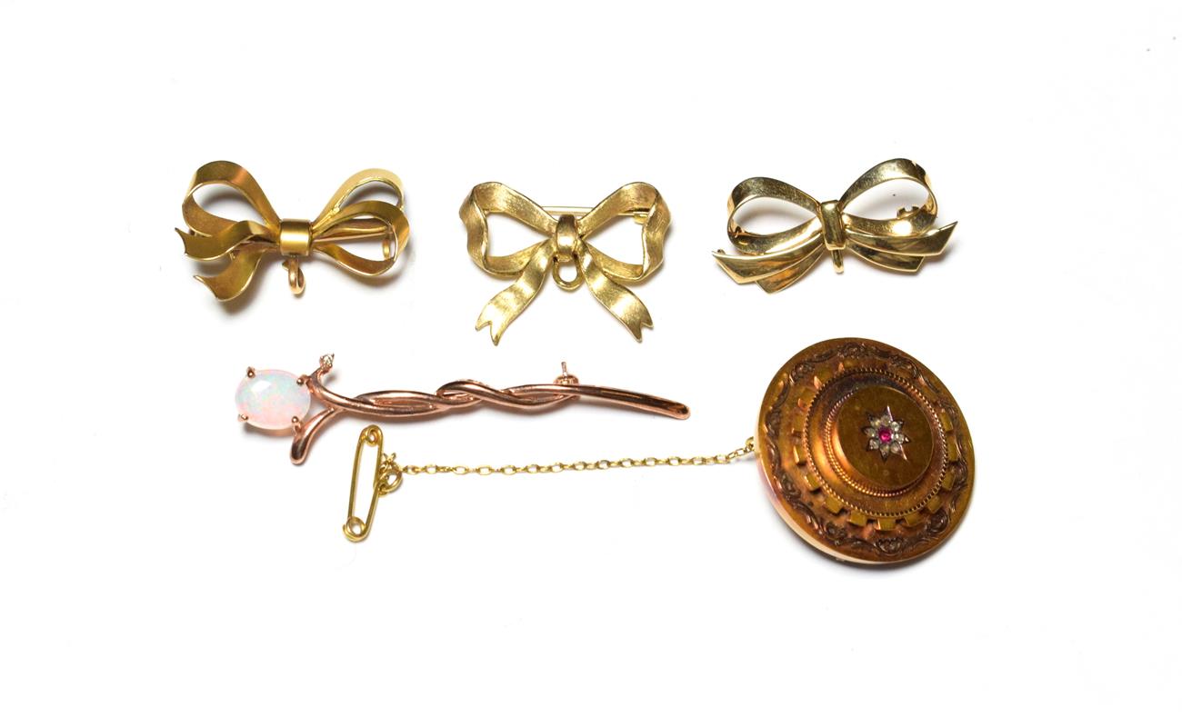 A ruby and diamond mourning brooch, stamped '15CT'; two 9 carat gold bow brooches; another bow