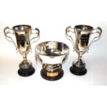 Two twin handled silver plated trophy cups, and a silver plated trophy bowl with ring and lion