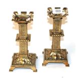 A pair of 19th century brass candlesticks with castellated tops
