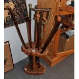 A carved wood stick stand with a collection of ten sticks