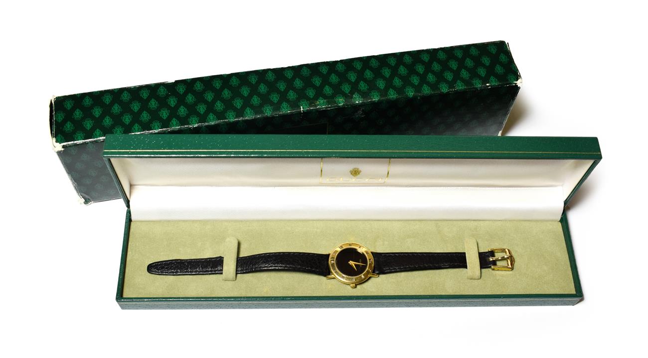 A lady's gold plated Gucci wristwatch, with Gucci booklets and box