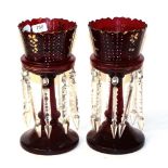 A pair of ruby glass table lustres, circa 1890, with painted foliate panels and prismatic drops,