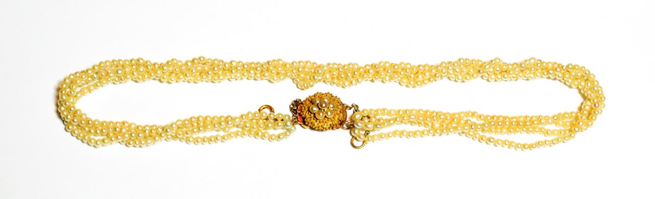 A four row seed pearl necklace, knotted to a filigree split pearl cluster clasp, length 40.5cm