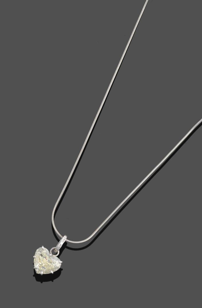 A Diamond Pendant on Chain, the heart shaped diamond in a white claw setting, on a white snake