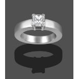 A Diamond Solitaire Ring, the princess cut diamond in a white four claw setting on a plain