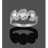 A Diamond Three Stone Ring, the graduated round brilliant cut diamonds in swirl tension settings, to