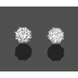 A Pair of Diamond Solitaire Earrings, the round brilliant cut diamonds in white claw settings, total