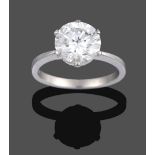 A Diamond Solitaire Ring, the round brilliant cut diamond in a white claw setting with a pear cut