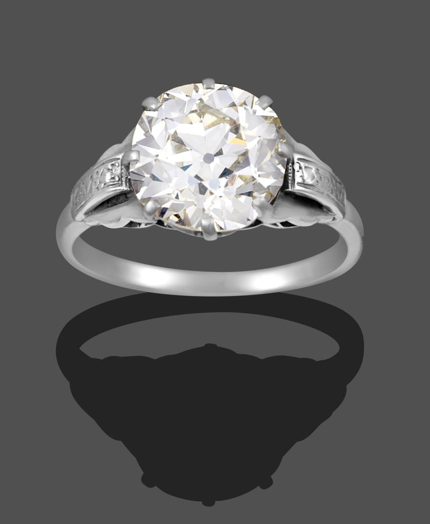 A Diamond Solitaire Ring, the old cut diamond in a white claw setting, to fancy panelled shoulders