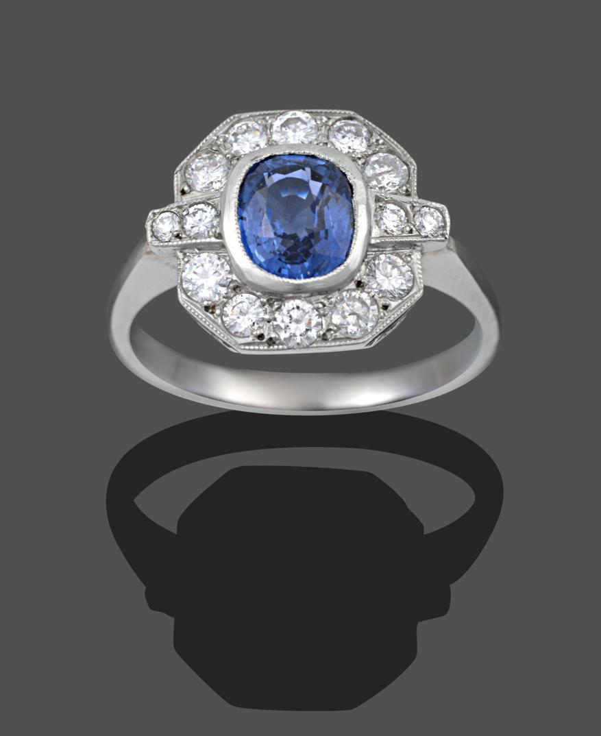 An Art Deco Style Sapphire and Diamond Cluster Ring, the cushion cut sapphire in a white