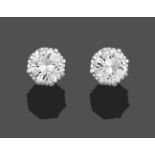 A Pair of Diamond Solitaire Earrings, the round brilliant cut diamonds in a white claw setting,