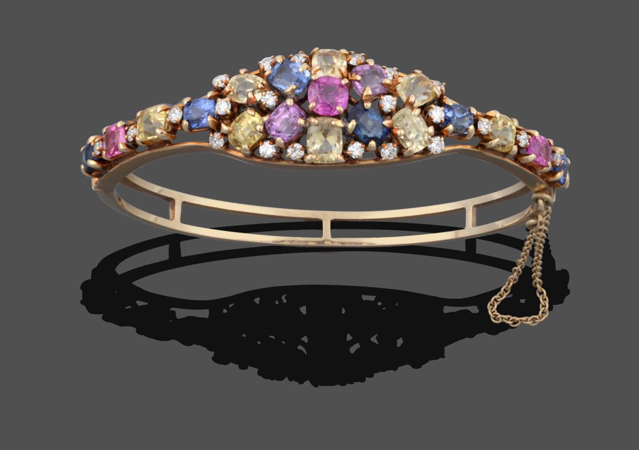 A Multi-Gemstone Cluster Bangle, the cluster set throughout with vari-shaped pink, blue, yellow