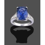 A Platinum Sapphire and Diamond Ring, the cushion cut sapphire in a four claw setting, to