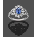 A Sapphire and Diamond Cluster Ring, the oval cut sapphire within a border of round brilliant cut