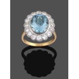 An Aquamarine and Diamond Cluster Ring, the oval cut aquamarine in a white rubbed over setting,