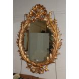 ^ A reproduction gilt framed oval mirror in the Rococo taste