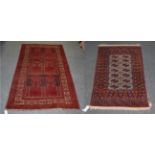 A Bokhara style rug with a red brick field, 123cm by 77cm and a Balouch rug,