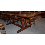 A reproduction Titchmarsh & Goodwin oak extending dining table on trestle base