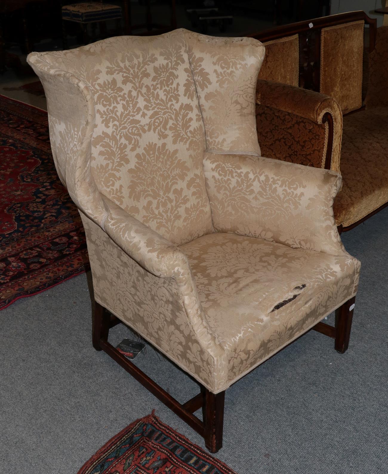 A George III mahogany framed wingback armchair